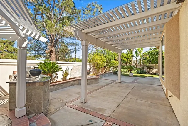 a view of a patio with a table and chairs under an umbrella
