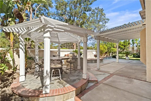 a living room with stainless steel appliances kitchen island granite countertop a refrigerator a sink dishwasher with a dining table and chairs with wooden floor