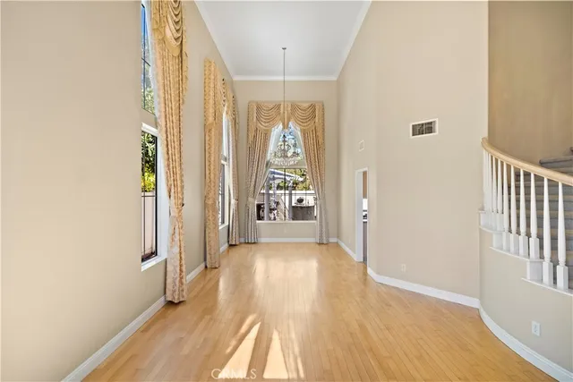 a view of a hallway with wooden floor and windows