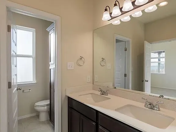 a view of an empty room with a window and a kitchen