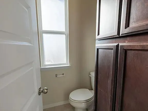 a view of an empty room with window and cabinet