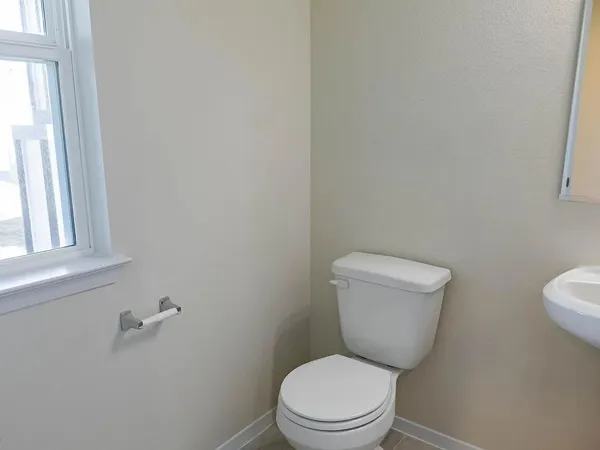 a white toilet sitting next to a window