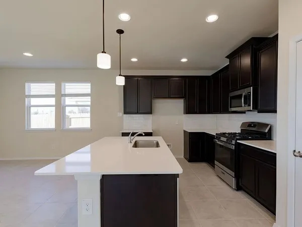 a kitchen with stainless steel appliances a sink stove and refrigerator