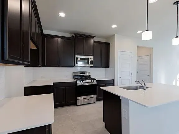 a kitchen with kitchen island a sink stainless steel appliances and cabinets