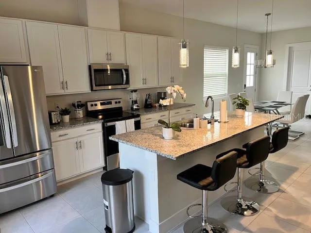 a kitchen with granite countertop a sink appliances and cabinets