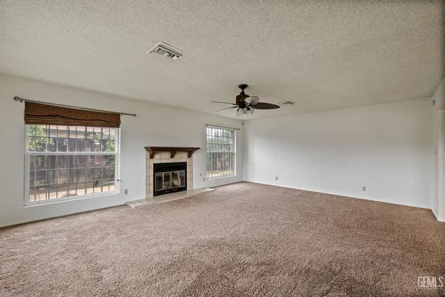 a view of an empty room with a fireplace and a window