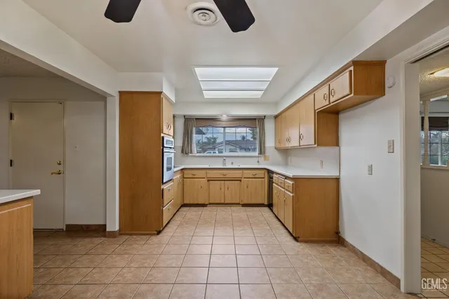 a large white kitchen with a sink and dishwasher a refrigerator with white cabinets
