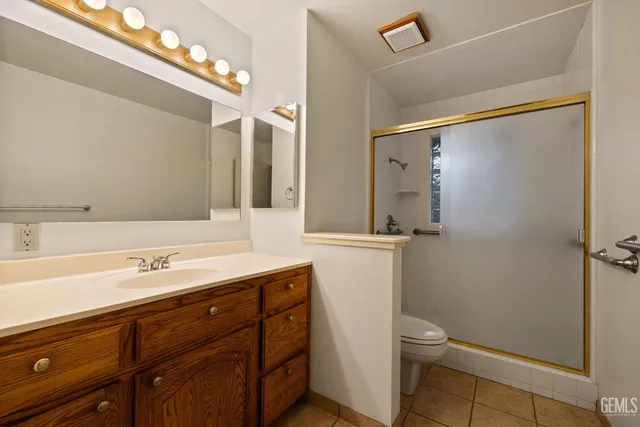 a bathroom with a sink a toilet a mirror and shower