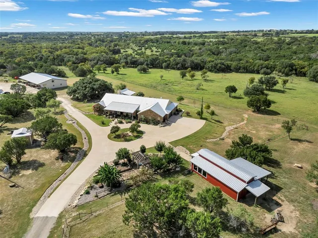 an aerial view of a house with a yard and lake view