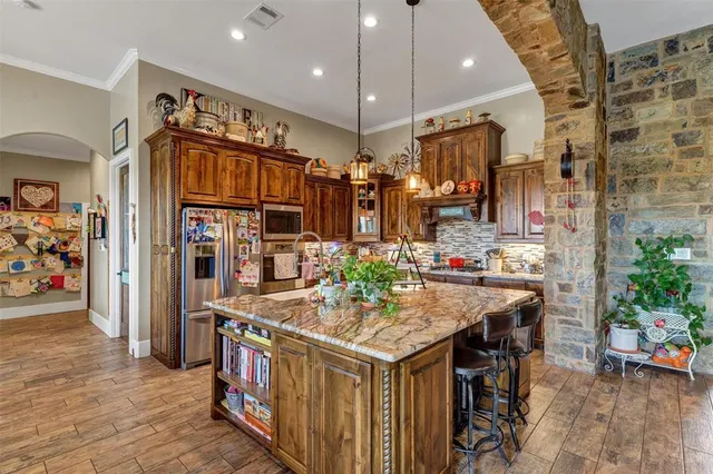 a kitchen that has a lot of cabinets and wooden floor