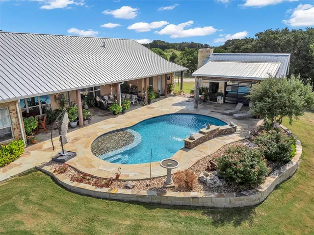 a view of a house with swimming pool and sitting area