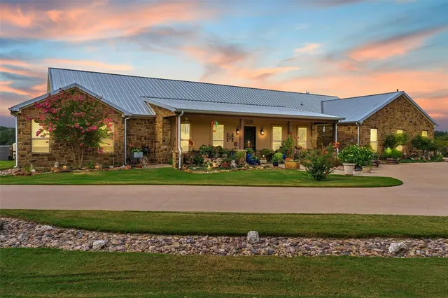 a view of a big house with a big yard and potted plants