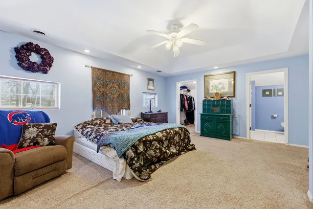a spacious bedroom with a bed a couch and a chandelier