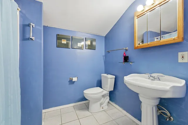 a bathroom with a sink toilet and a mirror