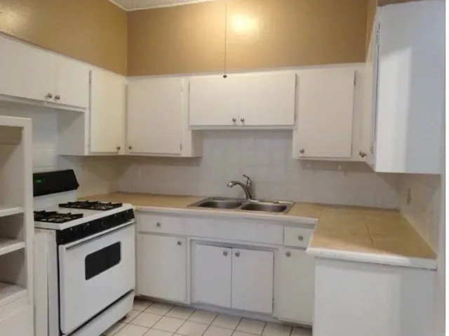 a kitchen with granite countertop white cabinets and white appliances