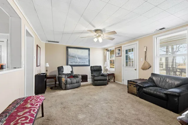 a living room with furniture ceiling fan and a window
