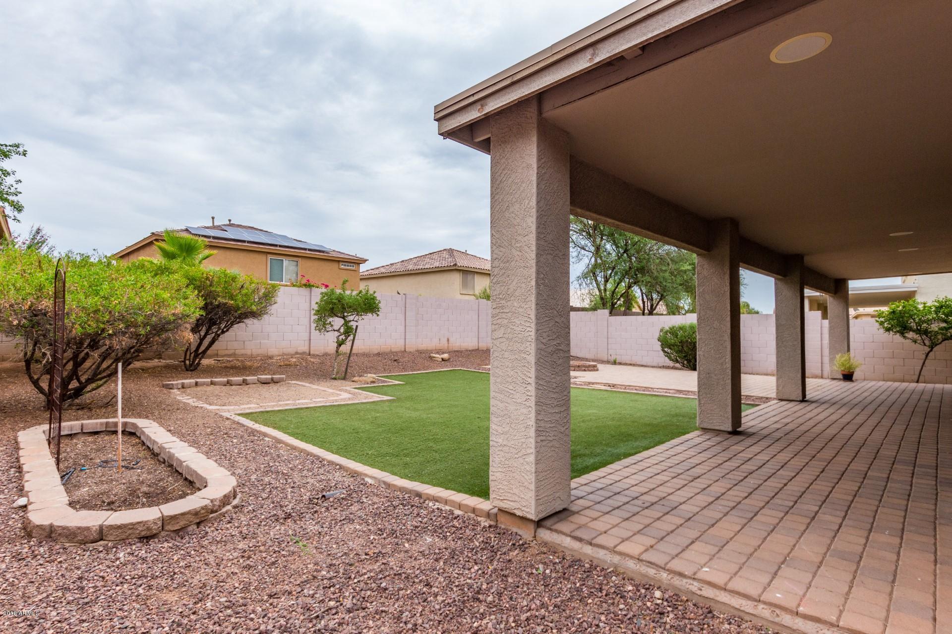 15770 West Calavar Road Surprise, AZ 85379 - Photo 19 of 21 a backyard of a house with lots of green space and seating space