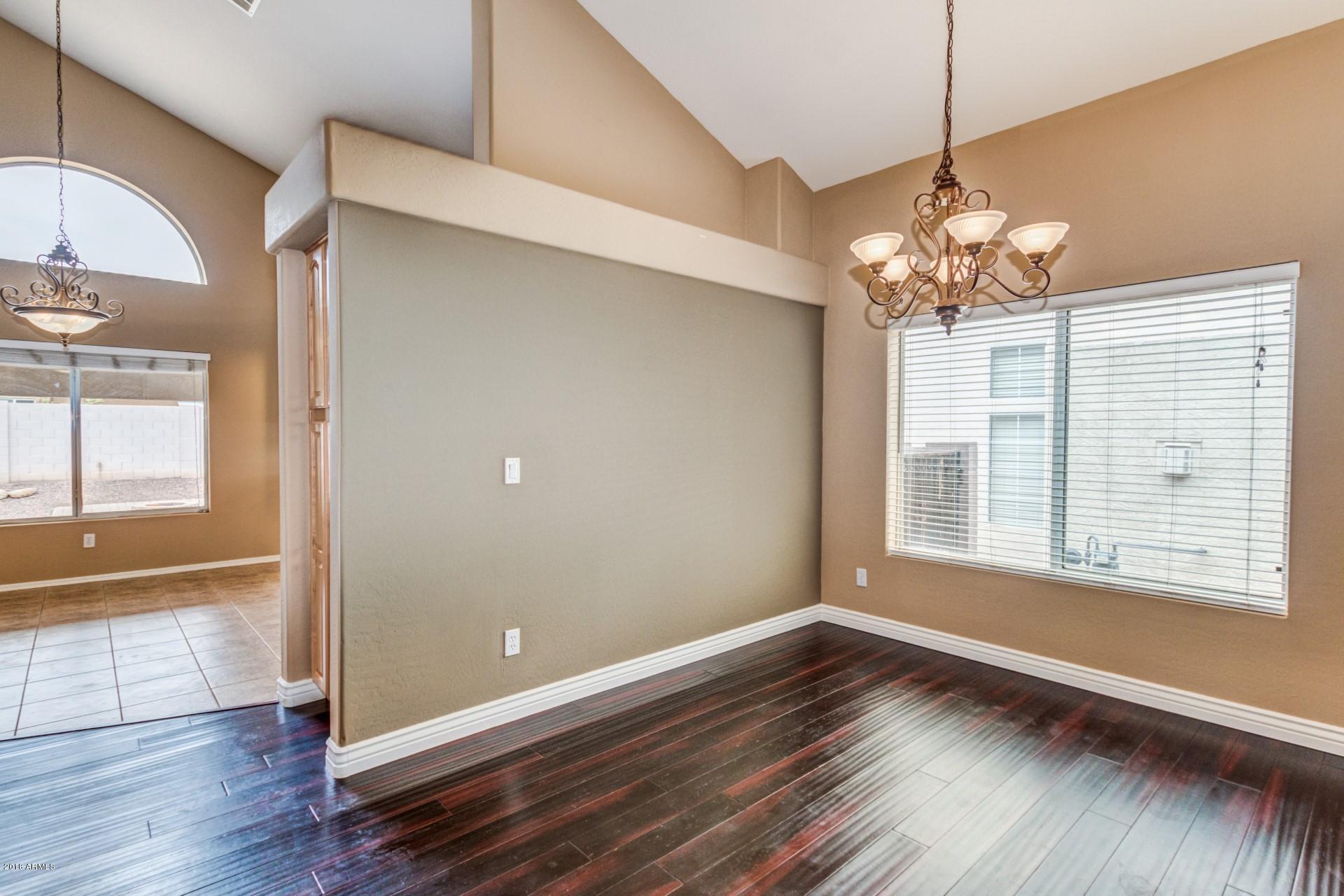 15770 West Calavar Road Surprise, AZ 85379 - Photo 6 of 21 an empty room with wooden floor and windows