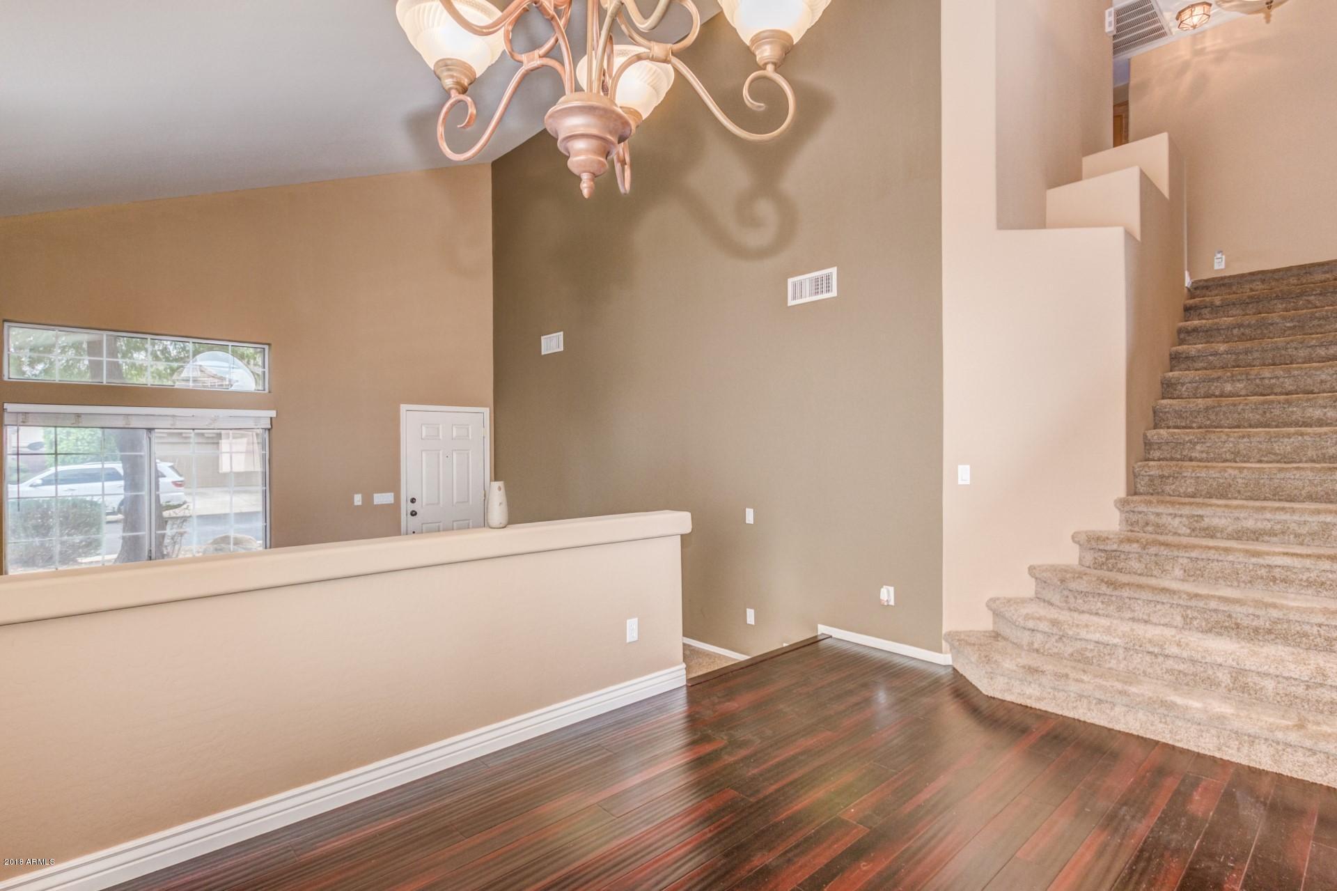15770 West Calavar Road Surprise, AZ 85379 - Photo 10 of 21 a view of a hallway with wooden floor and staircase