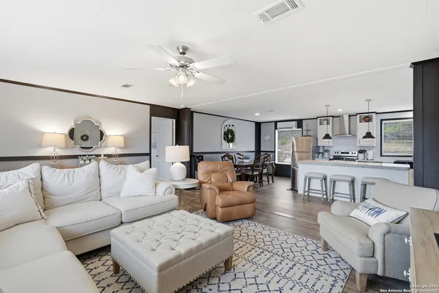 a living room with furniture and view of kitchen