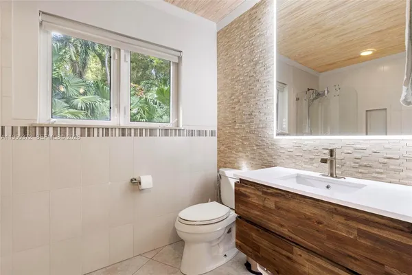 a bathroom with a sink a toilet and a mirror