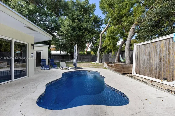 a swimming pool with outdoor seating and yard