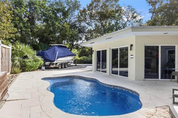 a view of a house with pool fire pit and chairs in the patio