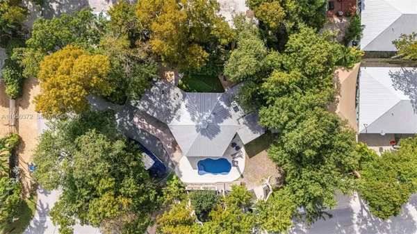 a view of a house with a yard and large trees