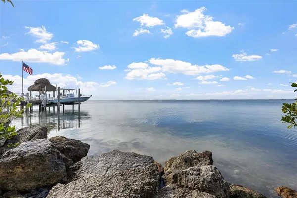 a view of backyard with outdoor seating and lake view