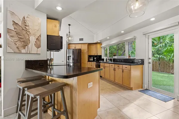 a kitchen with stainless steel appliances kitchen island granite countertop a sink and cabinets