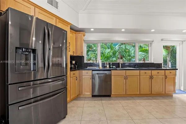 a kitchen with stainless steel appliances granite countertop a refrigerator and a sink