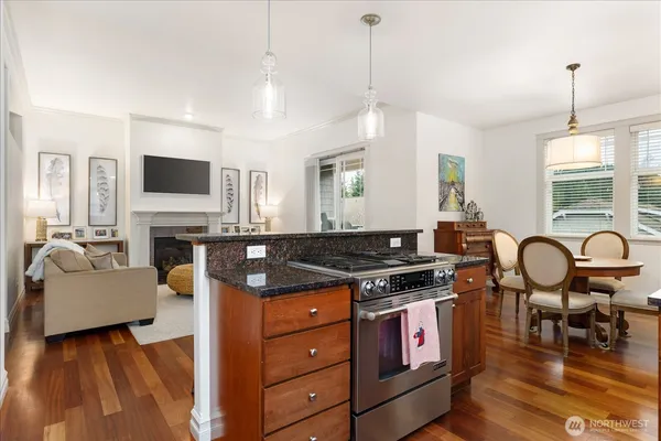 a kitchen with stainless steel appliances granite countertop a stove and a wooden floors