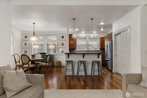 a living room with furniture kitchen view and a chandelier