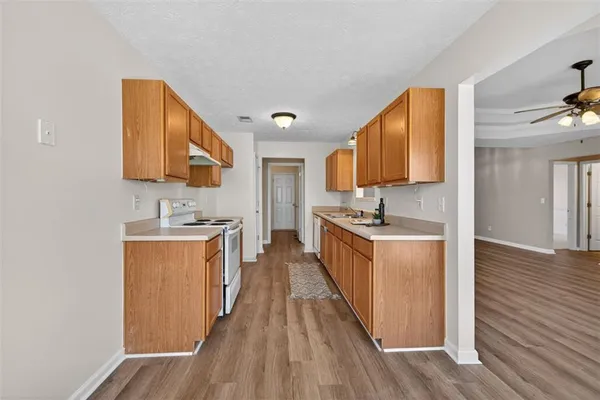 a kitchen with stainless steel appliances granite countertop a sink stove and wooden floor