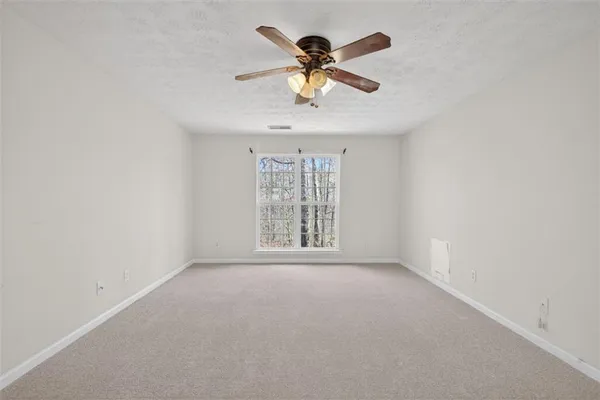 an empty room with a window and a fan