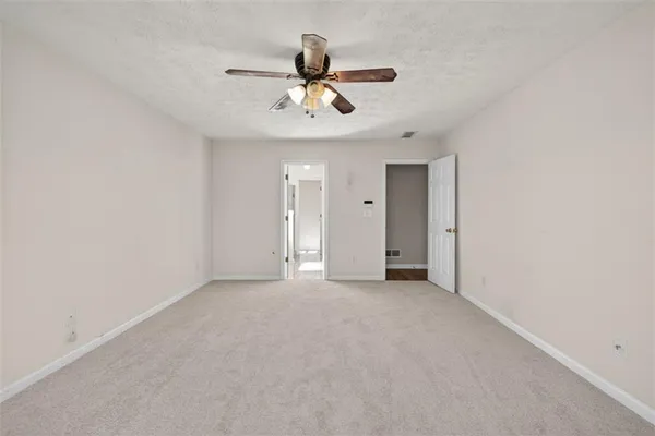 a view of an empty room with a ceiling fan