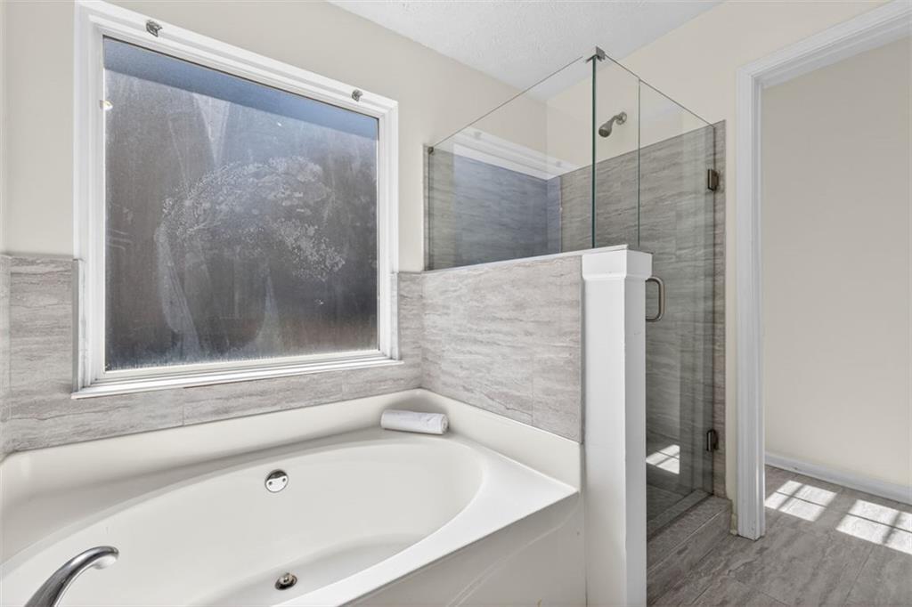 775 Sterling Place Monroe, GA 30656 - Photo 22 of 37 a bathroom with a bathtub and a shower