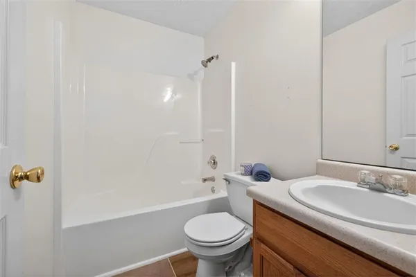 a bathroom with a granite countertop sink a toilet and shower