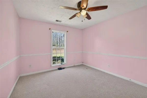 an empty room with a window and a fan