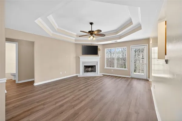 a view of an empty room with a window and wooden floor