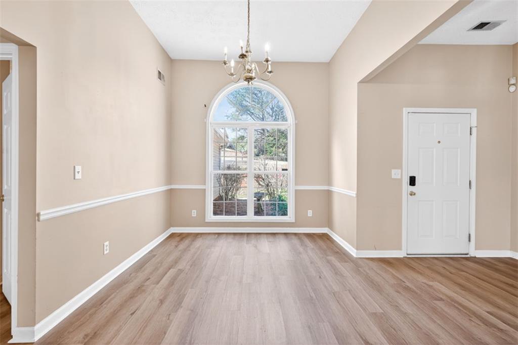 775 Sterling Place Monroe, GA 30656 - Photo 8 of 37 wooden floor in an empty room with a window