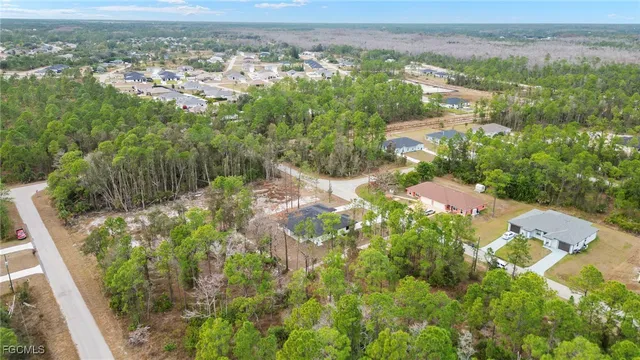 an aerial view of residential house with outdoor space and trees all around