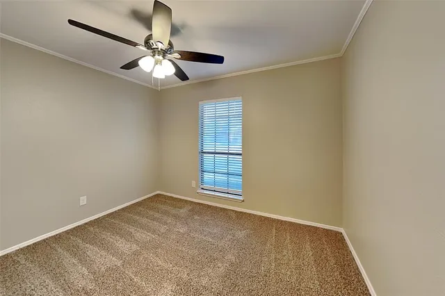 an empty room with a window and a fan