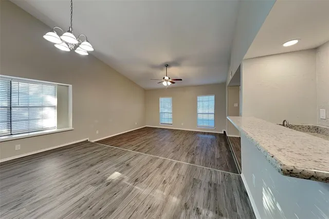 a view of a room with wooden floors and chandelier