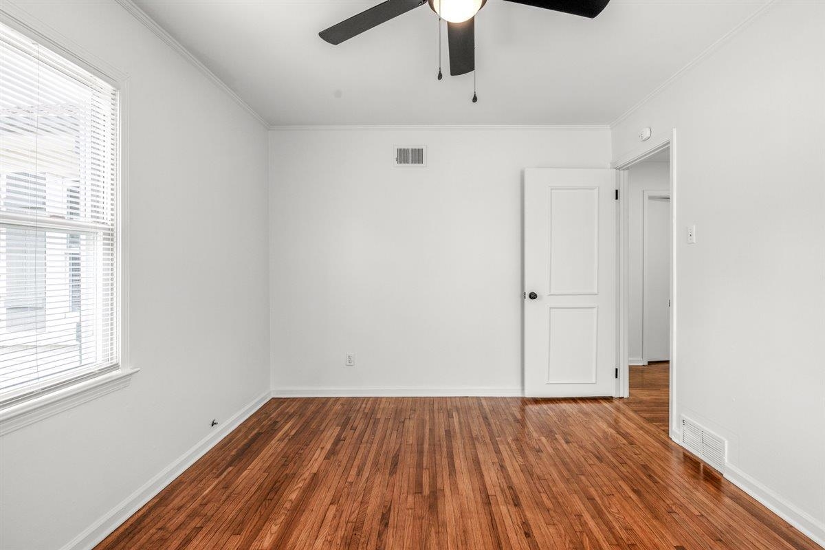 1244 Wells Station Road Memphis, TN 38122 - Photo 21 of 36 Empty room featuring dark wood-style flooring, ornamental molding, and ceiling fan