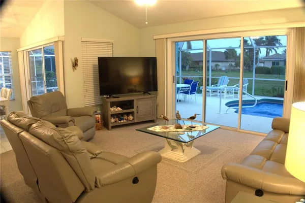a living room with furniture and a floor to ceiling window