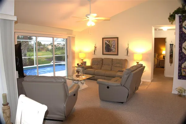 a living room with furniture a lamp and a floor to ceiling window