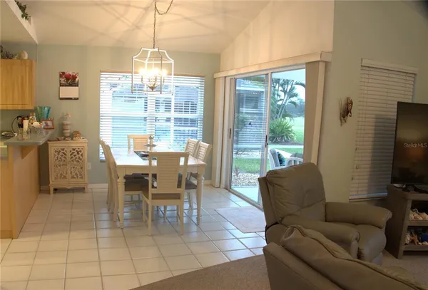 a dining room with furniture and large windows