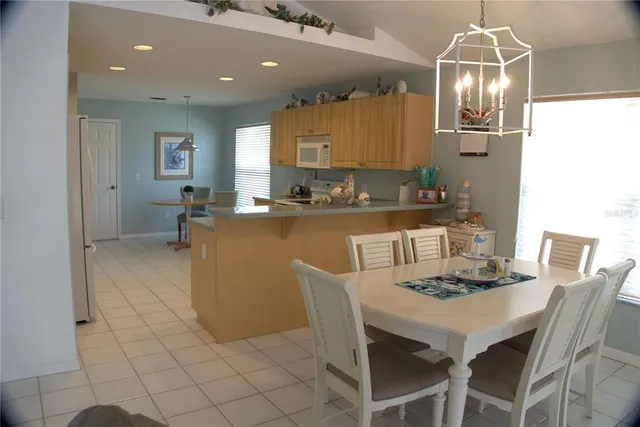 a kitchen with a dining table chairs and microwave