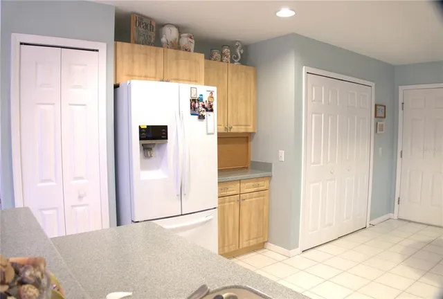 a view of a kitchen with refrigerator and wooden floor